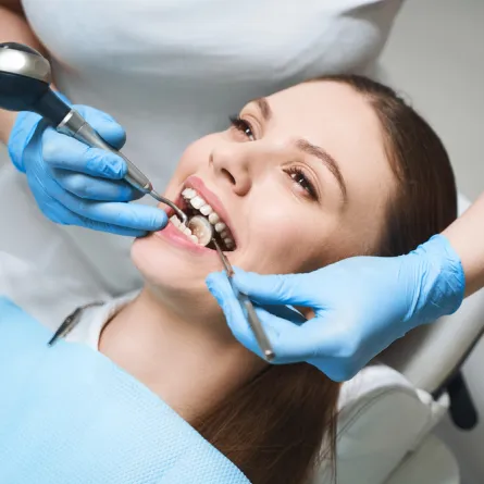 a woman getting her teeth checked by a dentist