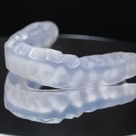 Custom-fitted night guard placed on a dental model to prevent teeth grinding and clenching.